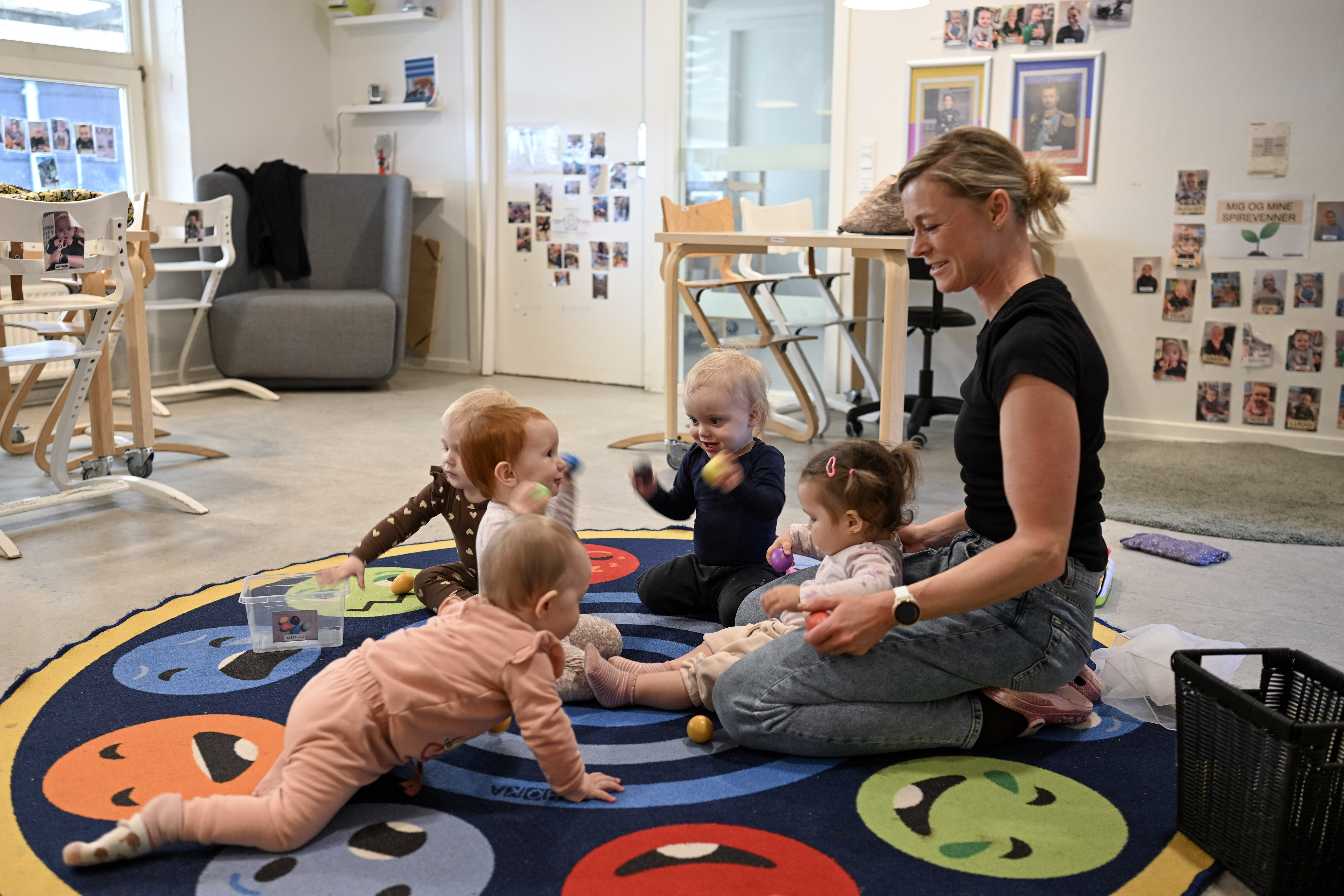 Voksen leger med børn på tæppe